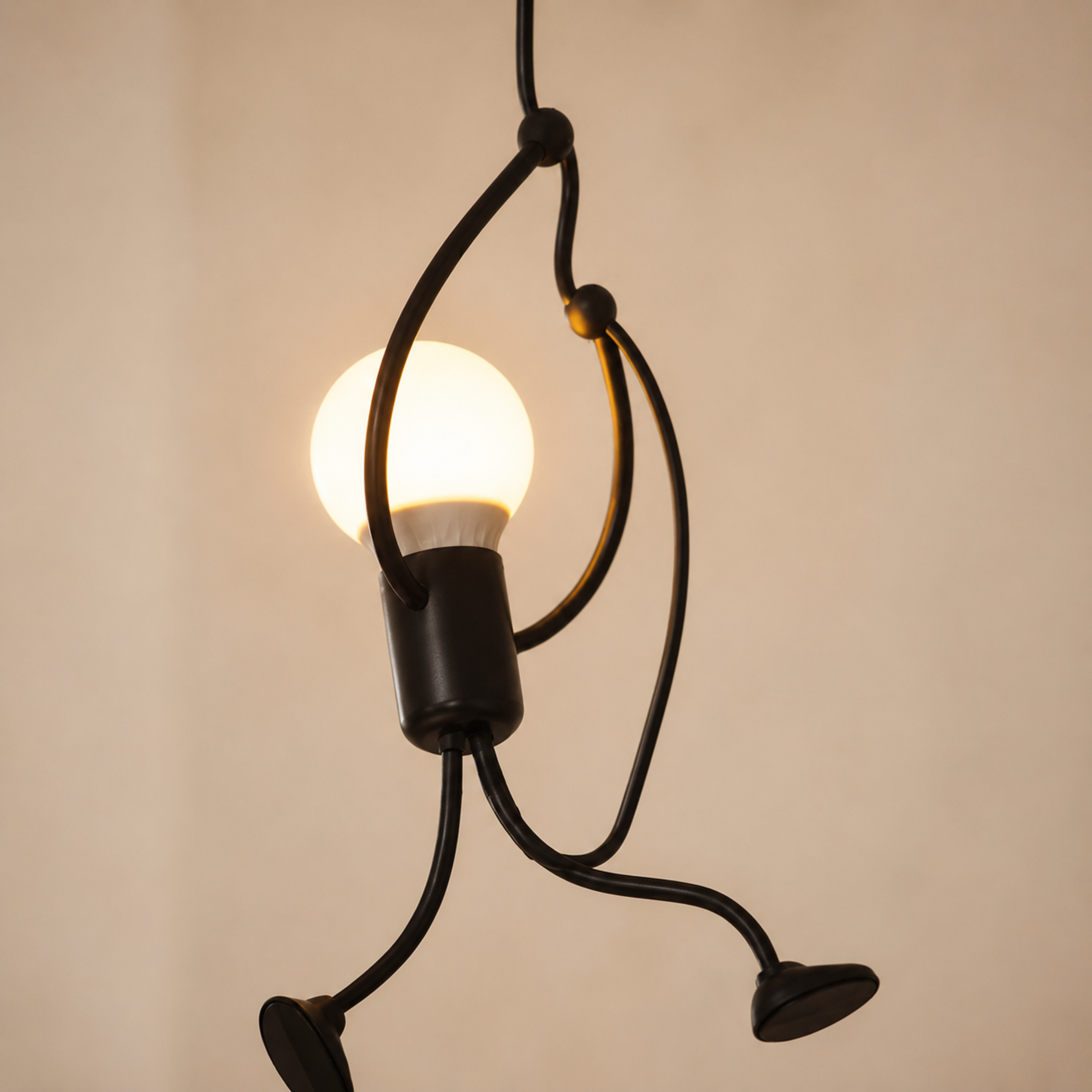 Lampada a sospensione nera con figura che si arrampica e lampadina a vista