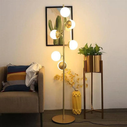 Lampada da terra oro con paralumi a globo in vetro e base in marmo
