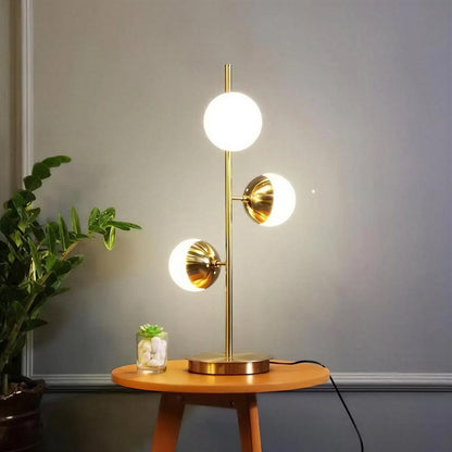 Lampada da terra oro con paralumi a globo in vetro e base in marmo