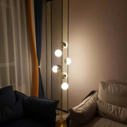 Lampada da terra oro con paralumi a globo in vetro e base in marmo