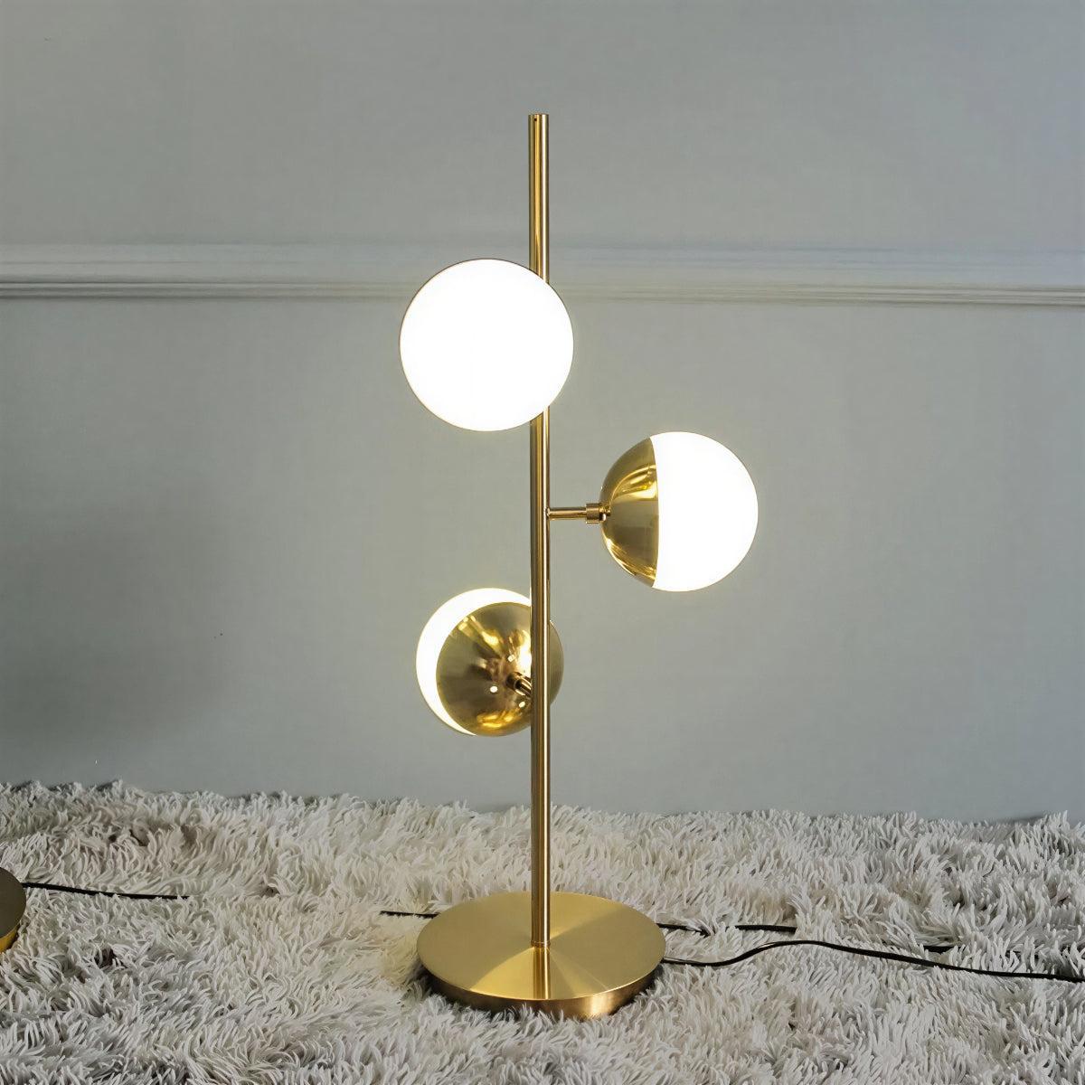 Lampada da terra oro con paralumi a globo in vetro e base in marmo